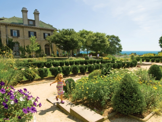Young girl running in front of Harkness Mansion at Harkness Memorial State Park