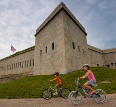Two kids bike riding in front of Fort Trumbull, New London