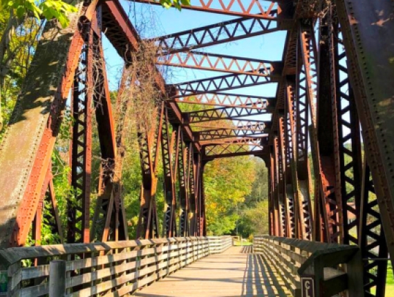A bridge with a metal frame and a wooden walkway.
