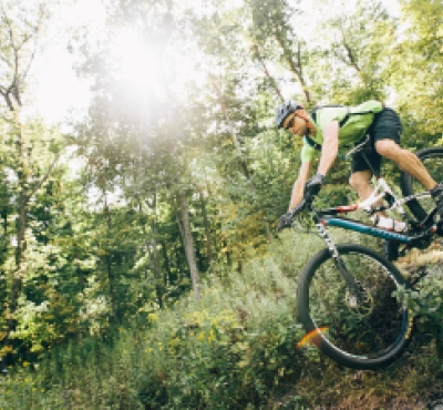 Man mountain biking through woods