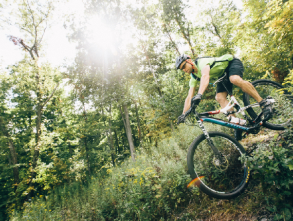 Man mountain biking through woods
